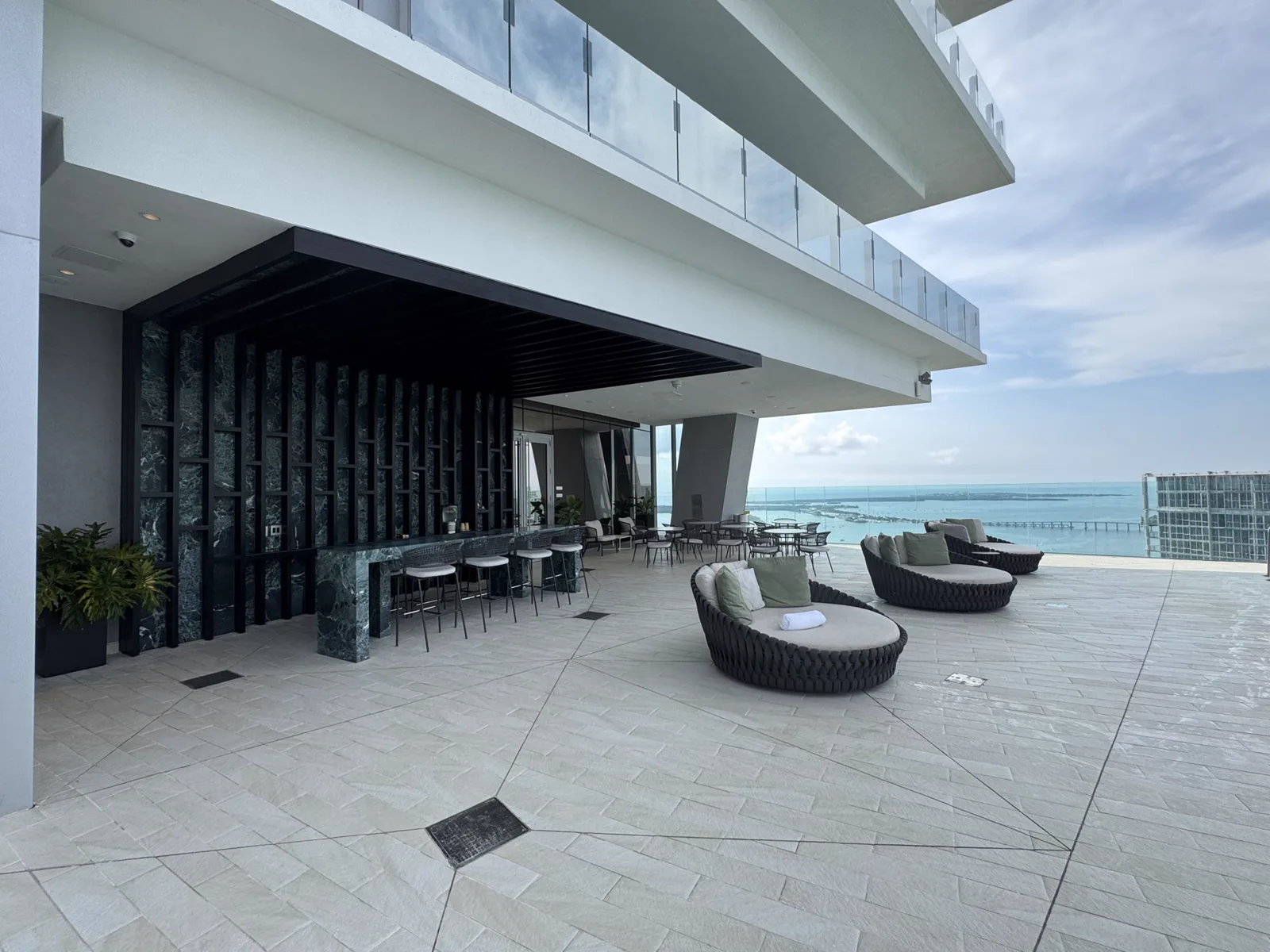 Rooftop amenity terrace with seating and waterfront views at Aston Martin Residences