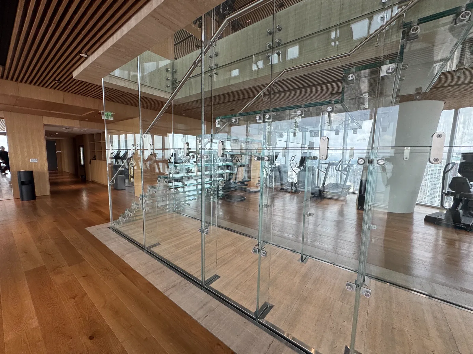 Glass-enclosed stairway beside the gym at Aston Martin Residences